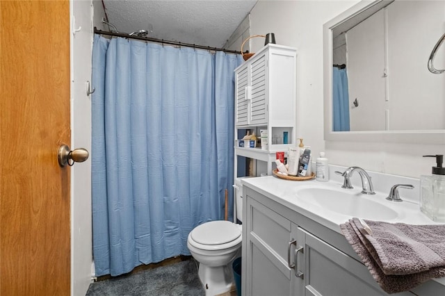 bathroom featuring toilet, vanity, walk in shower, and a textured ceiling