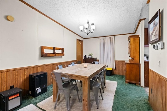 carpeted dining room with a textured ceiling, crown molding, and a chandelier