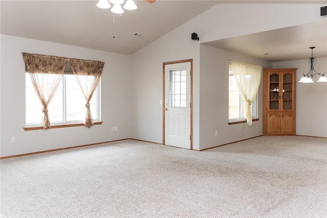 unfurnished living room with lofted ceiling, plenty of natural light, and carpet flooring