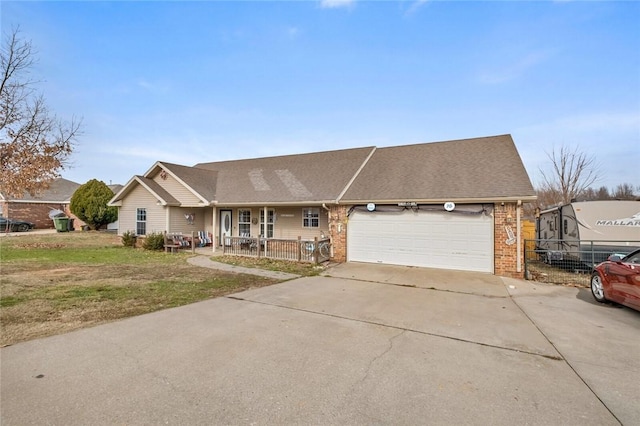 ranch-style house featuring a garage, a front lawn, and covered porch