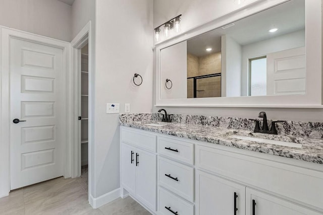 bathroom featuring a shower with shower door, vanity, and tile patterned floors