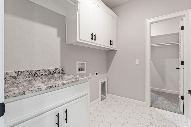 laundry room with light tile patterned floors, hookup for an electric dryer, hookup for a washing machine, and cabinets