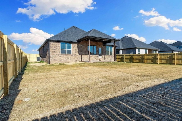 back of property with cooling unit and a lawn