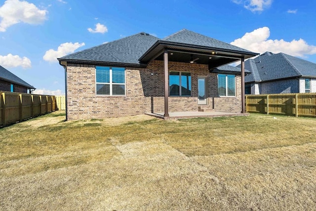 back of property with a yard and a patio