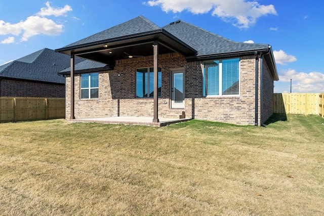 back of house featuring a lawn and a patio