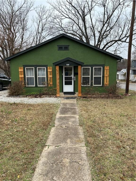 bungalow-style house with a front lawn