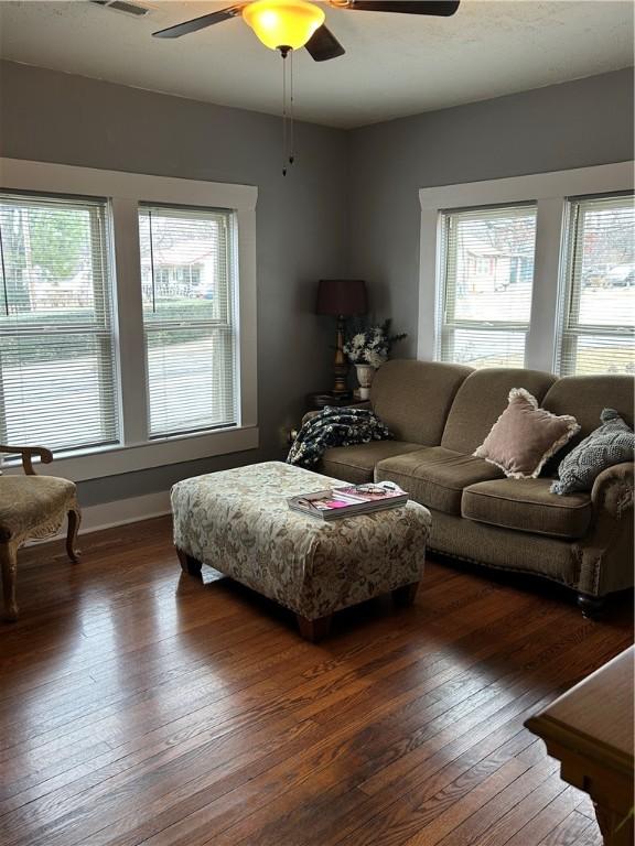 living room featuring ceiling fan and dark wood-type flooring