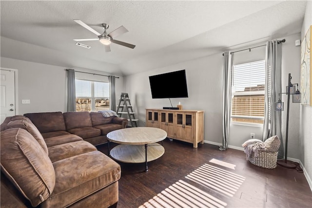 living room with ceiling fan, vaulted ceiling, a textured ceiling, and dark hardwood / wood-style flooring