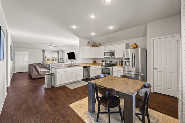 kitchen with appliances with stainless steel finishes, sink, white cabinets, and kitchen peninsula