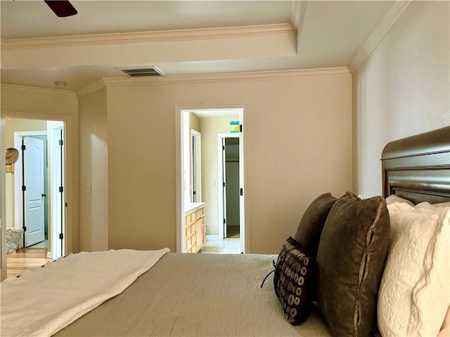 bedroom featuring ceiling fan, ornamental molding, a walk in closet, and ensuite bath