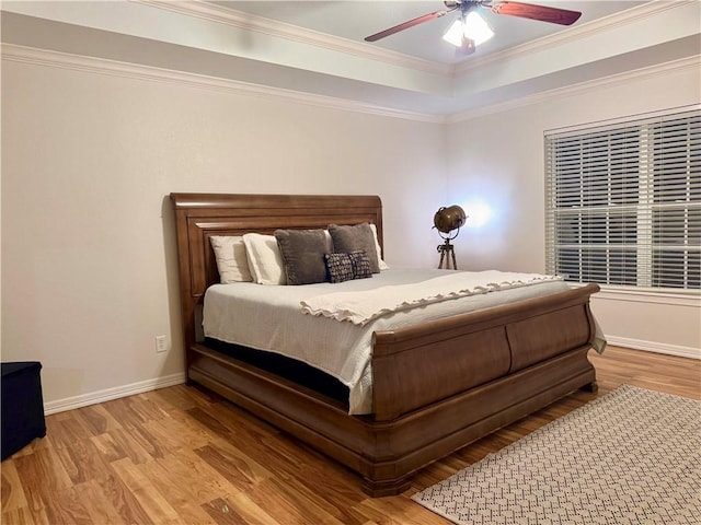 bedroom with light wood-type flooring, ceiling fan, and crown molding