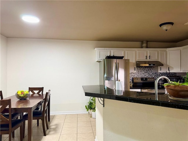 kitchen with light tile patterned floors, white cabinetry, kitchen peninsula, appliances with stainless steel finishes, and tasteful backsplash