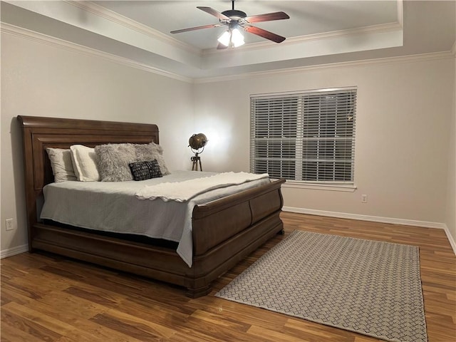 bedroom featuring ceiling fan, hardwood / wood-style floors, crown molding, and a raised ceiling