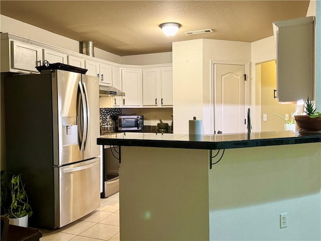 kitchen with kitchen peninsula, white cabinetry, a kitchen breakfast bar, stainless steel appliances, and light tile patterned floors