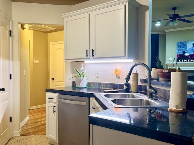 kitchen with light tile patterned floors, dishwasher, white cabinets, and sink