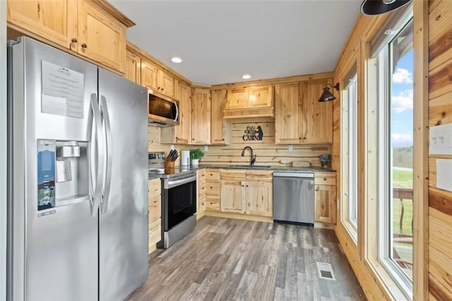 kitchen with appliances with stainless steel finishes, sink, light brown cabinets, and dark hardwood / wood-style floors