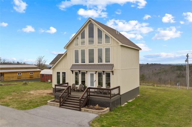 back of property featuring a wooden deck, a yard, and french doors