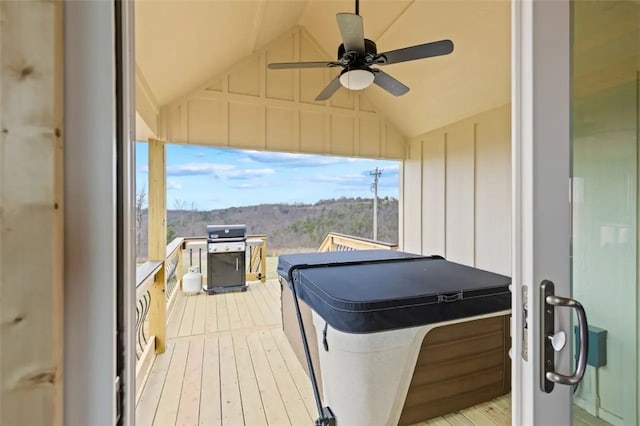 wooden deck with ceiling fan, area for grilling, and a hot tub