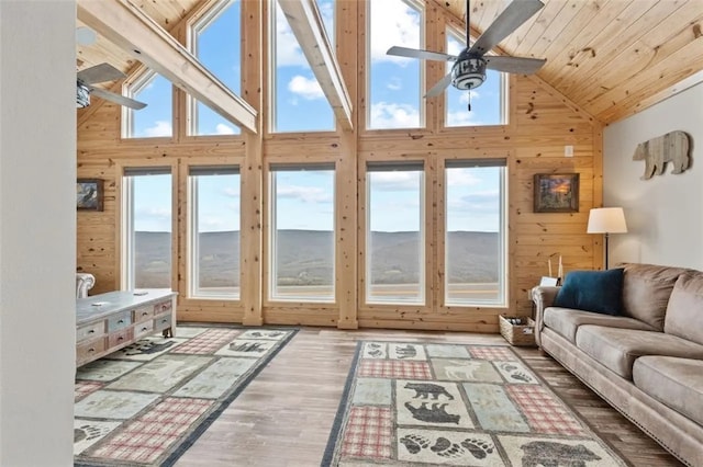 sunroom featuring ceiling fan, vaulted ceiling, plenty of natural light, and wooden ceiling