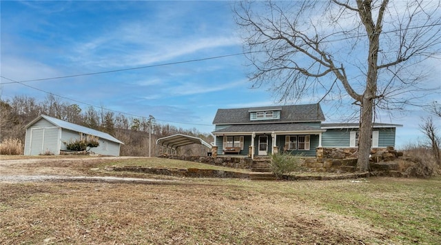 view of front of property with a carport, a shed, covered porch, and a front yard