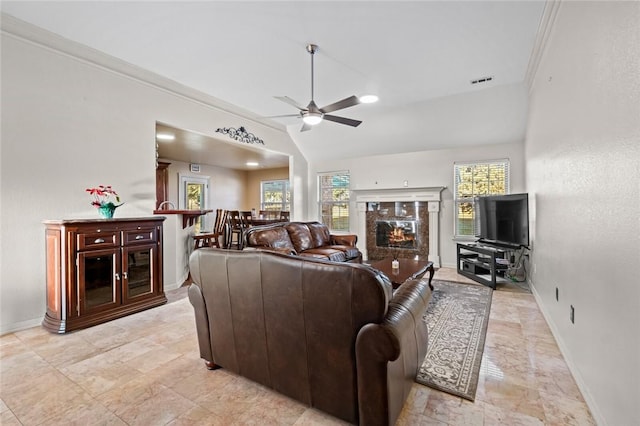 living room with a premium fireplace, ceiling fan, a wealth of natural light, and lofted ceiling