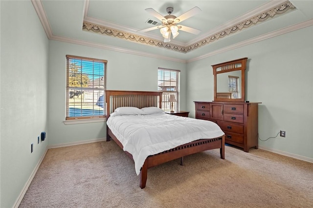 carpeted bedroom featuring ceiling fan, a tray ceiling, and crown molding