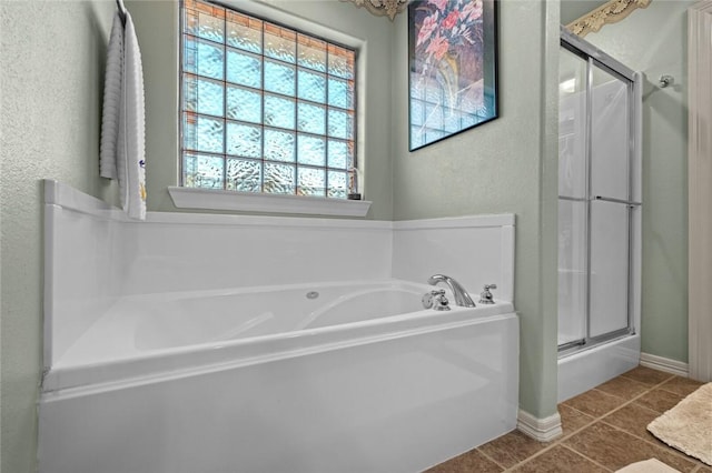 bathroom with shower with separate bathtub and tile patterned floors