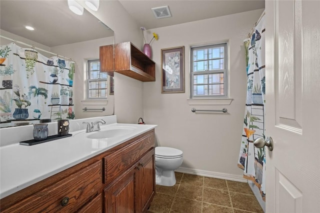 bathroom with a wealth of natural light, toilet, and vanity