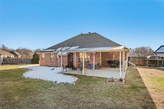 back of house featuring a lawn and a patio