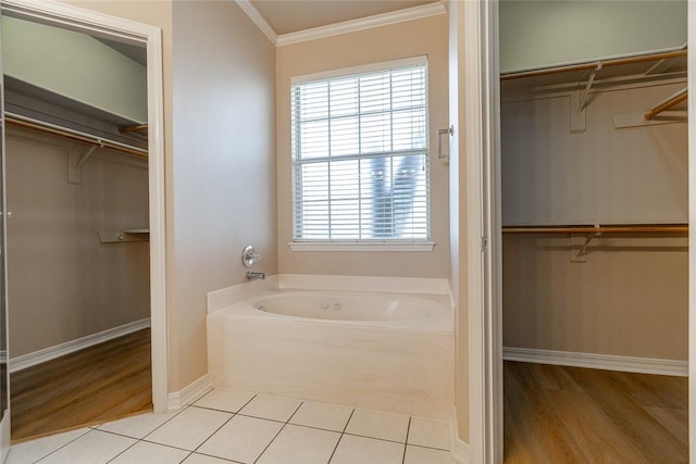 bathroom featuring tile patterned flooring, ornamental molding, and a washtub