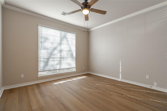 spare room with ceiling fan, a wealth of natural light, crown molding, and hardwood / wood-style flooring