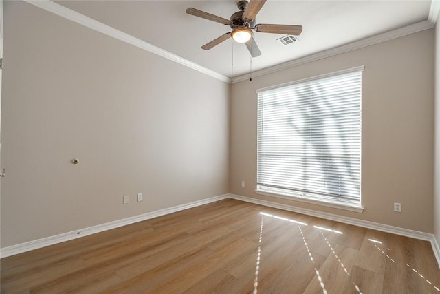 spare room featuring ceiling fan, ornamental molding, and light wood-type flooring