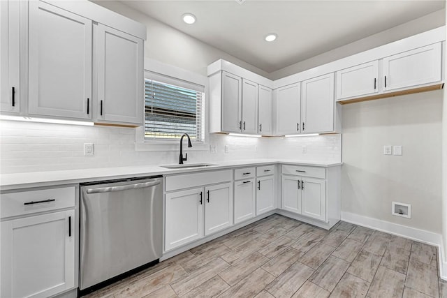 kitchen featuring baseboards, a sink, light countertops, dishwasher, and tasteful backsplash