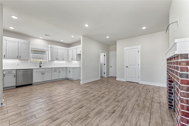 kitchen with visible vents, recessed lighting, a fireplace, a sink, and dishwasher