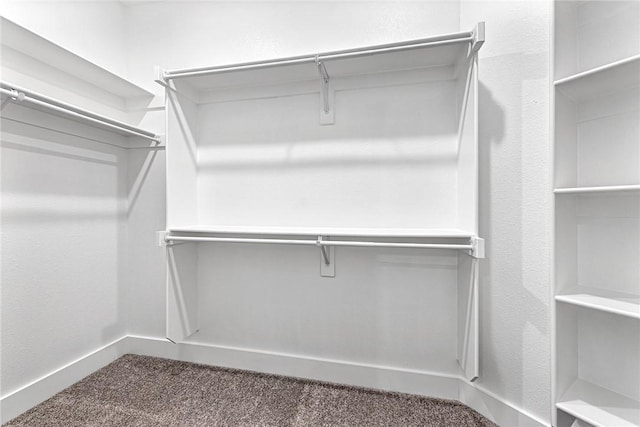 spacious closet featuring dark carpet