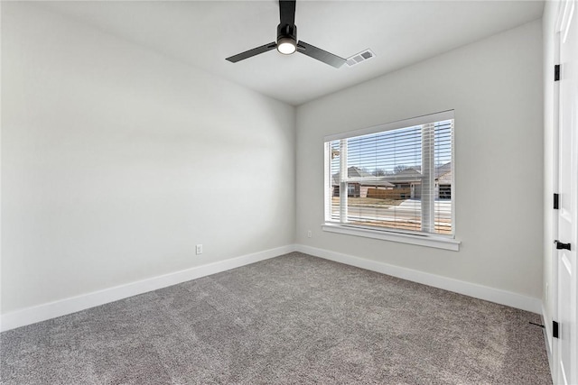 carpeted spare room with baseboards, visible vents, and ceiling fan