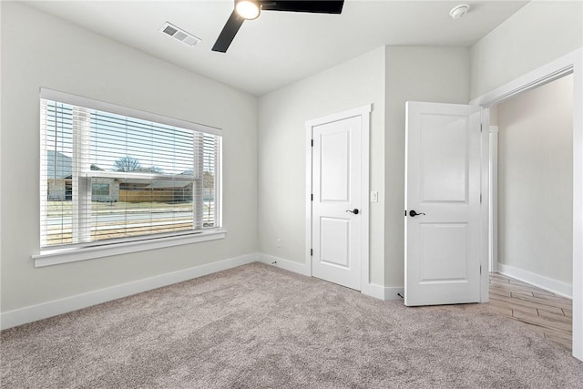 unfurnished bedroom with visible vents, light carpet, and baseboards