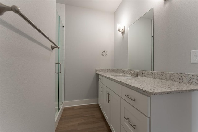 bathroom featuring hardwood / wood-style floors, an enclosed shower, and vanity