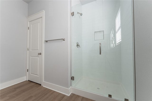 bathroom with hardwood / wood-style floors and a shower with door