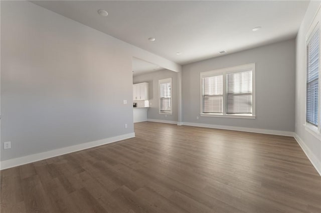 unfurnished room with dark wood-type flooring