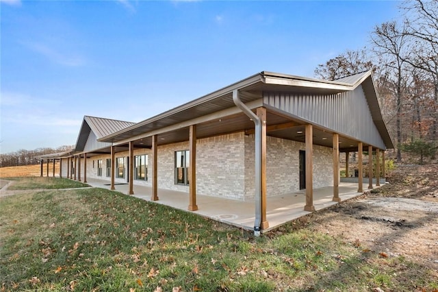 view of side of property with a patio area and a yard