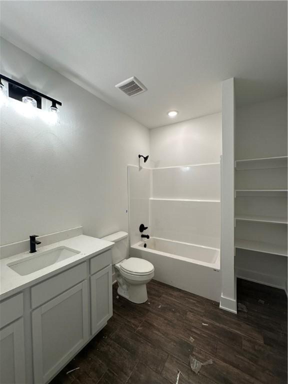 full bathroom with toilet, bathing tub / shower combination, wood-type flooring, and vanity