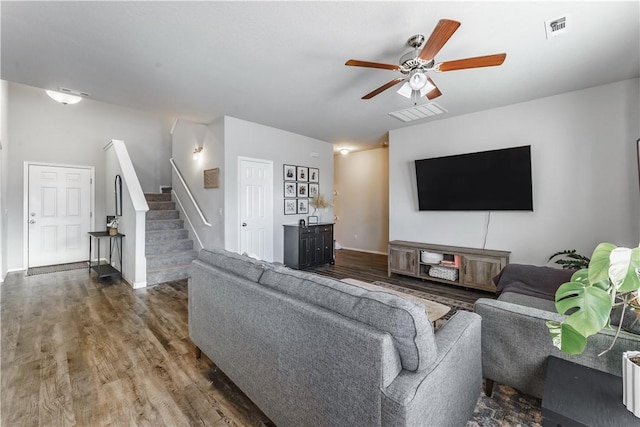 living room featuring ceiling fan and dark hardwood / wood-style flooring