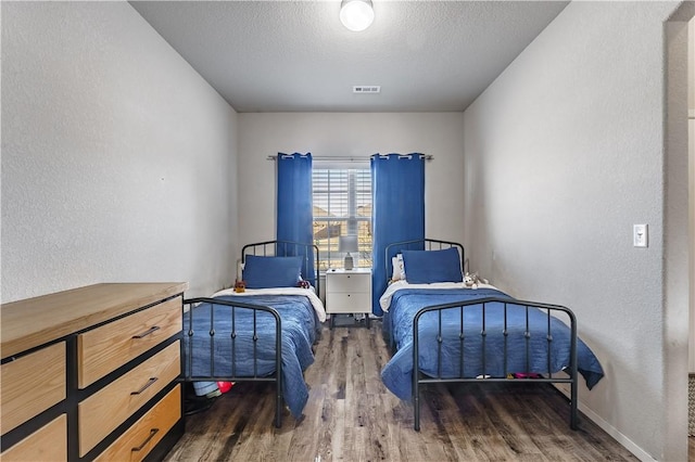 bedroom featuring dark hardwood / wood-style floors and a textured ceiling