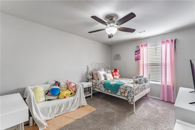 bedroom featuring carpet floors, ceiling fan, visible vents, and a textured ceiling