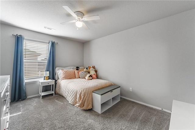 bedroom featuring baseboards, visible vents, dark carpet, and a textured ceiling