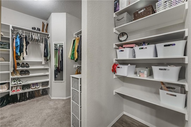 walk in closet featuring dark colored carpet