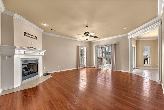 unfurnished living room with ceiling fan, light wood-type flooring, ornamental molding, and a fireplace