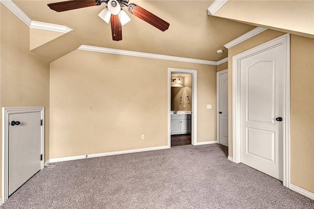 unfurnished bedroom with ceiling fan, ensuite bathroom, ornamental molding, and dark colored carpet