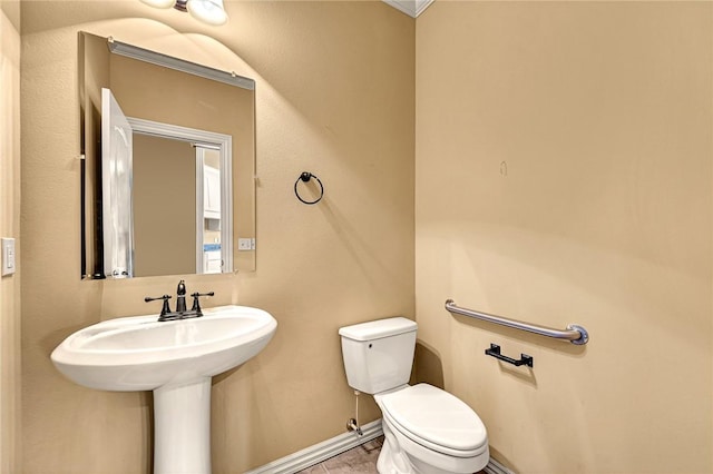 bathroom featuring toilet and ornamental molding